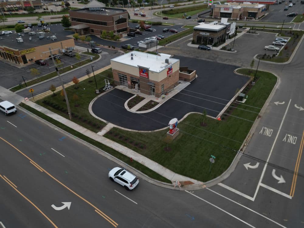 Aerial view of a fast-food restaurant surrounded by commercial buildings and traffic.